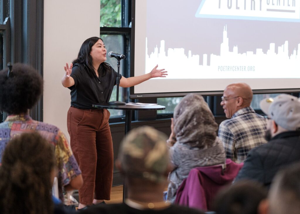 Helene Achanzar, the Director of Programs, speaks to a crowd at the 2022 Summer Poetry Party.